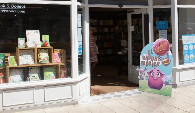 Entrada a una pequeña librería de barrio con display de suelo troquelado