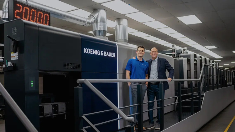 Nathan Elzer (left), Paperboard Process Engineering Manager at Grafika Print Inc., and Bernie Elzer III (right), President and CEO of Grafika Print Inc., standing in front of their Koenig & Bauer Rapida 106 &copy; Grafika Print Inc.